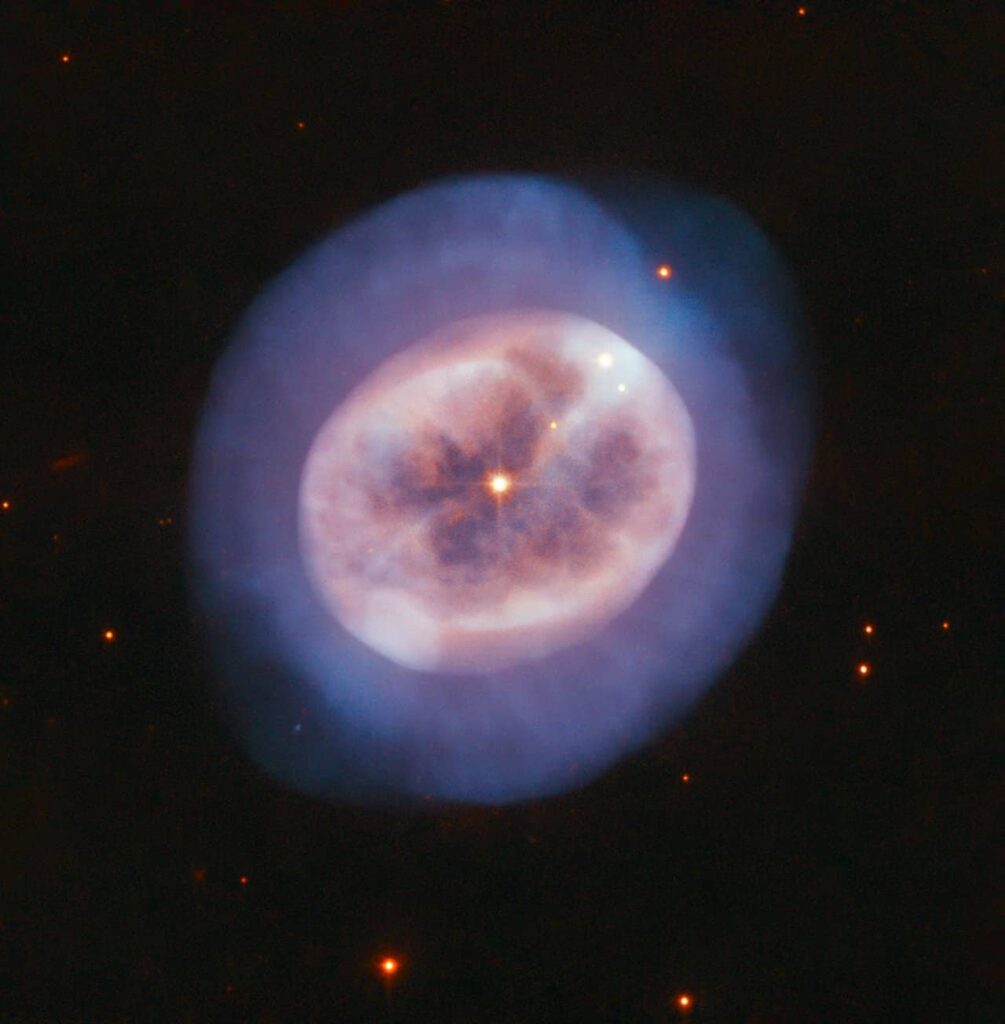 his rounded object, named NGC 2022 is a vast orb of gas in space, cast off by an ageing star. The star is visible in the orb's centre, shining through the gases it formerly held onto for most of its stellar life.